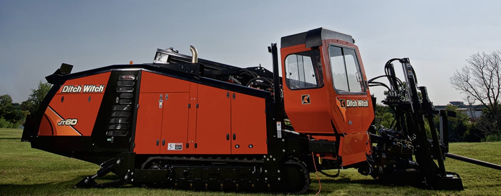 Ditch Witch JT60 directional drill with operator cab and rod loader, parked on grass