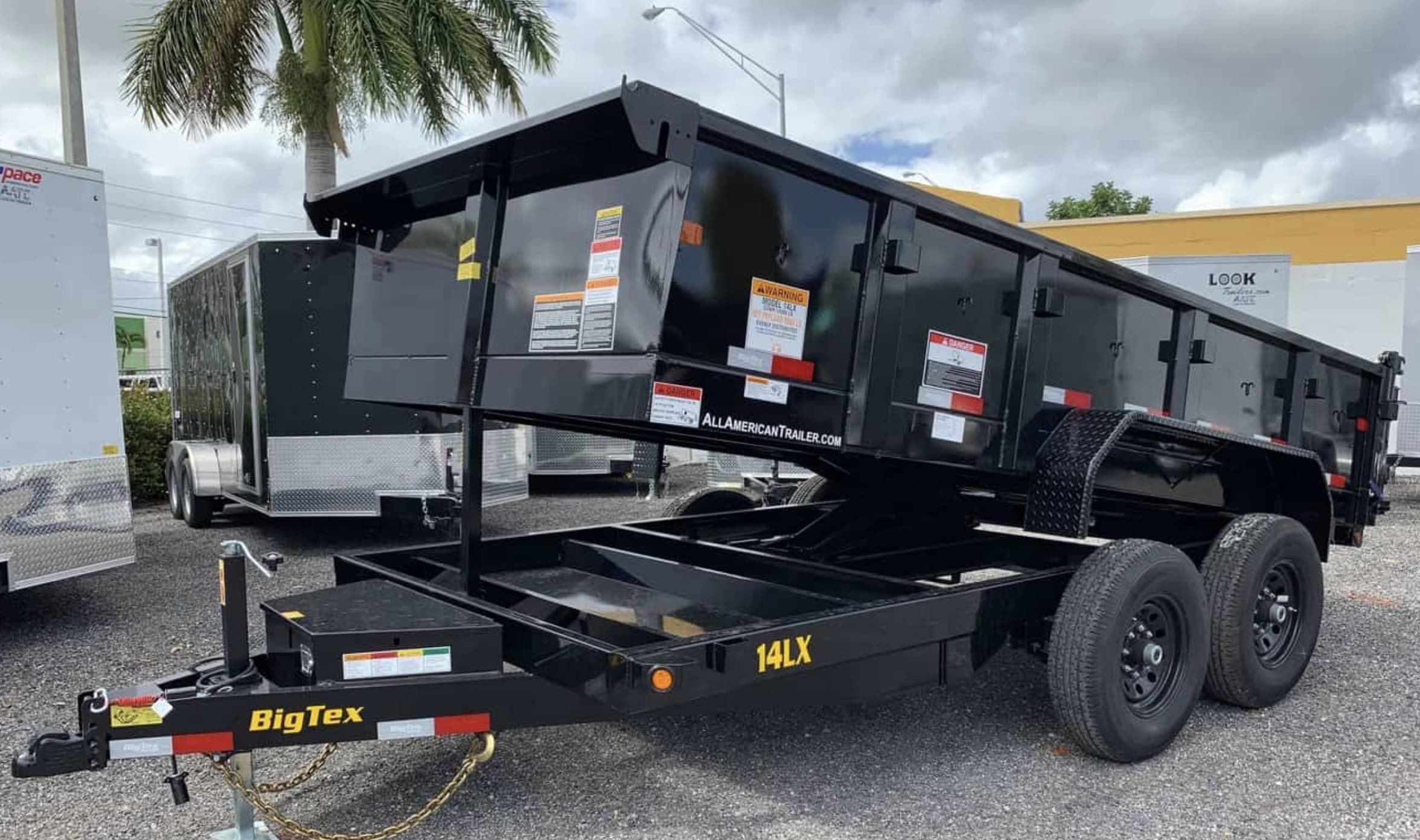 14 ft dump trailer with the bed raised, tandem axles and a ramp-style tongue