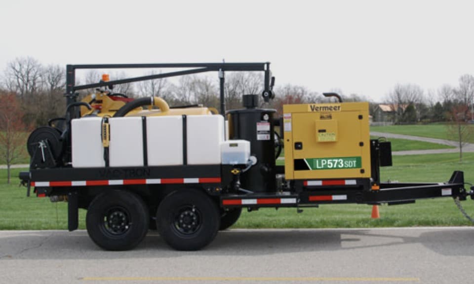 Vermeer vacuum excavator on a tandem-axle trailer with water tanks and hose reel